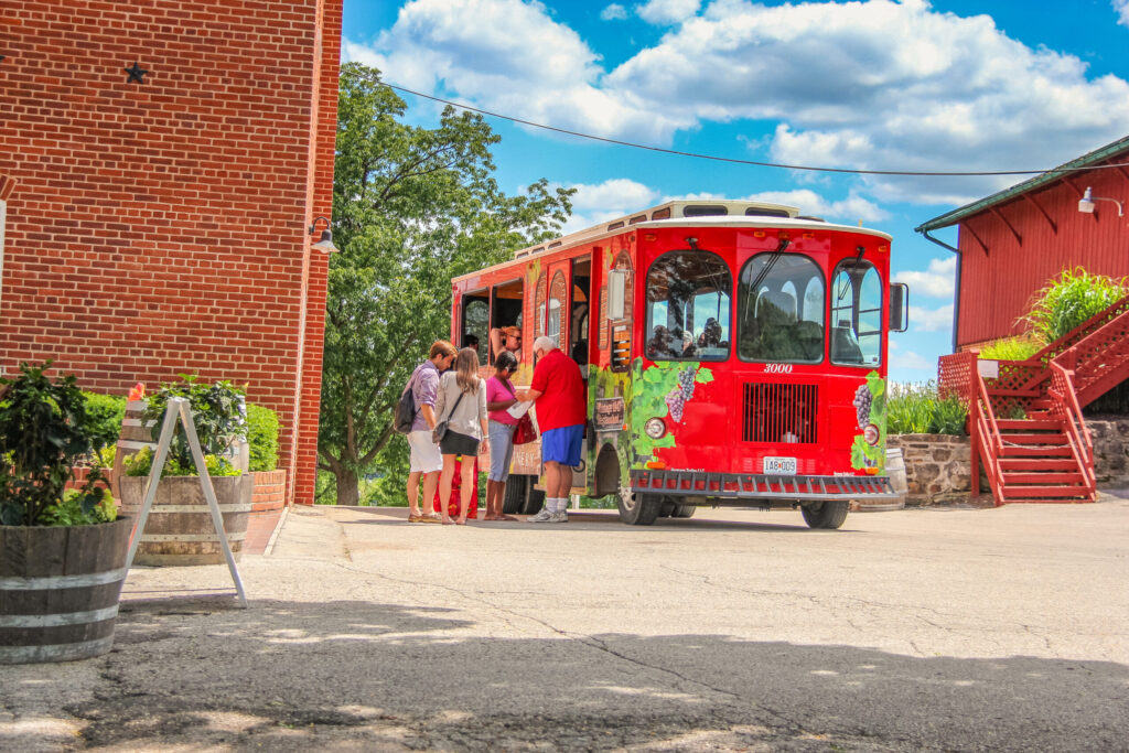 Visitors boarding the red Hermann trolley outside the Stone Hill winery buildings